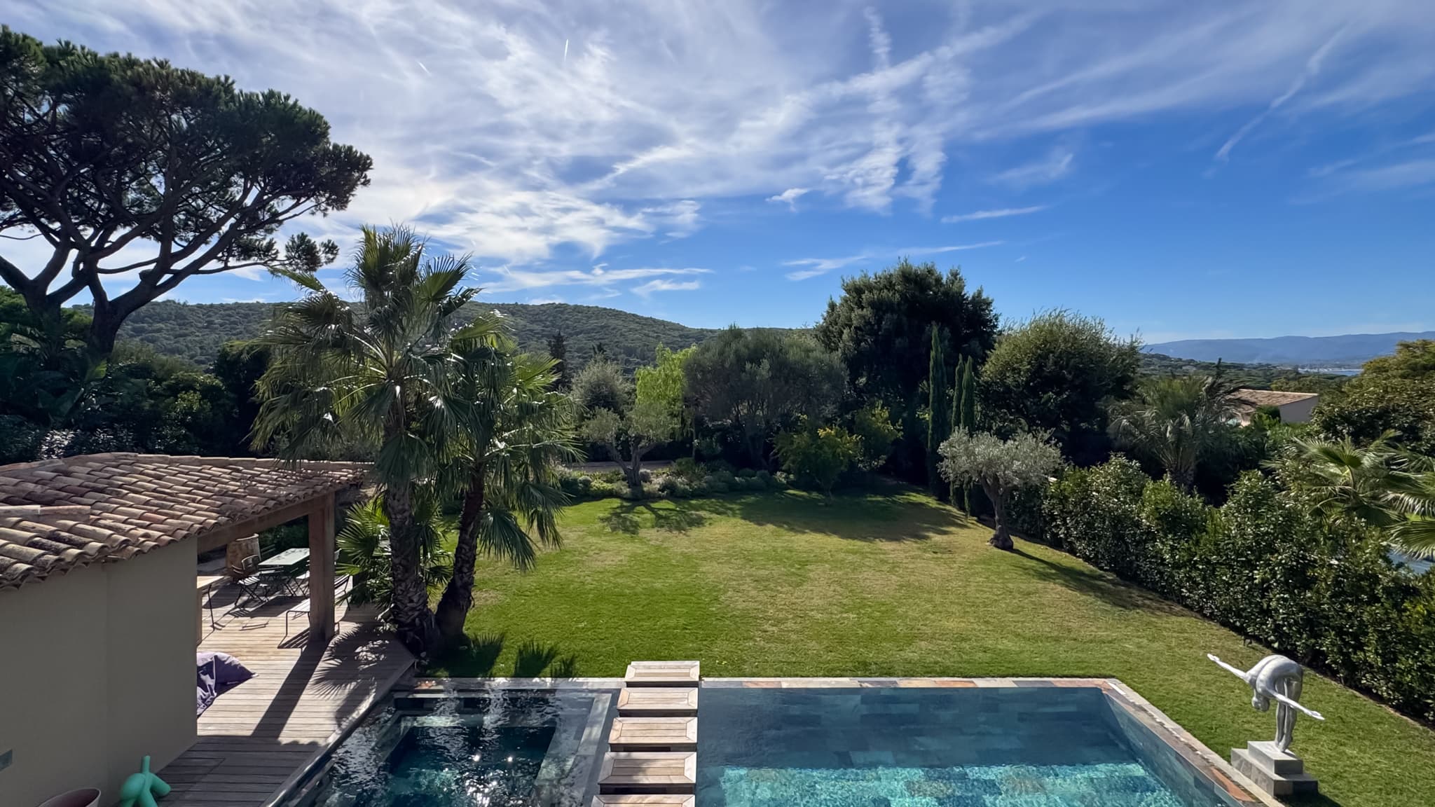 Vue dégagée sur le jardin paysager depuis cette villa de luxe à vendre à Saint-Tropez, idéalement située dans un domaine privé sécurisé à pied du village.