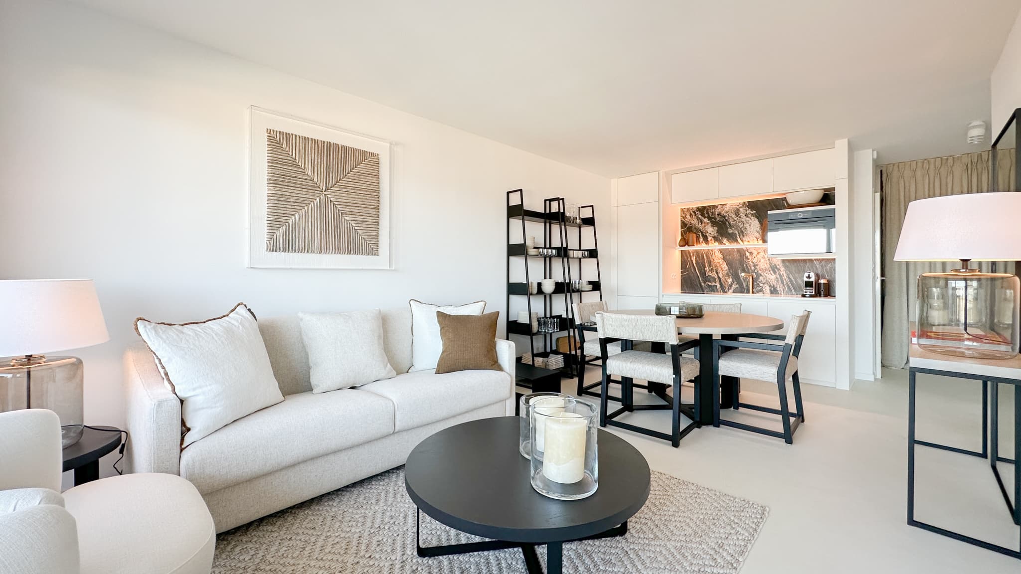 Salon lumineux et design d’un appartement à vendre à Saint-Tropez, ouvrant sur la terrasse vue mer.