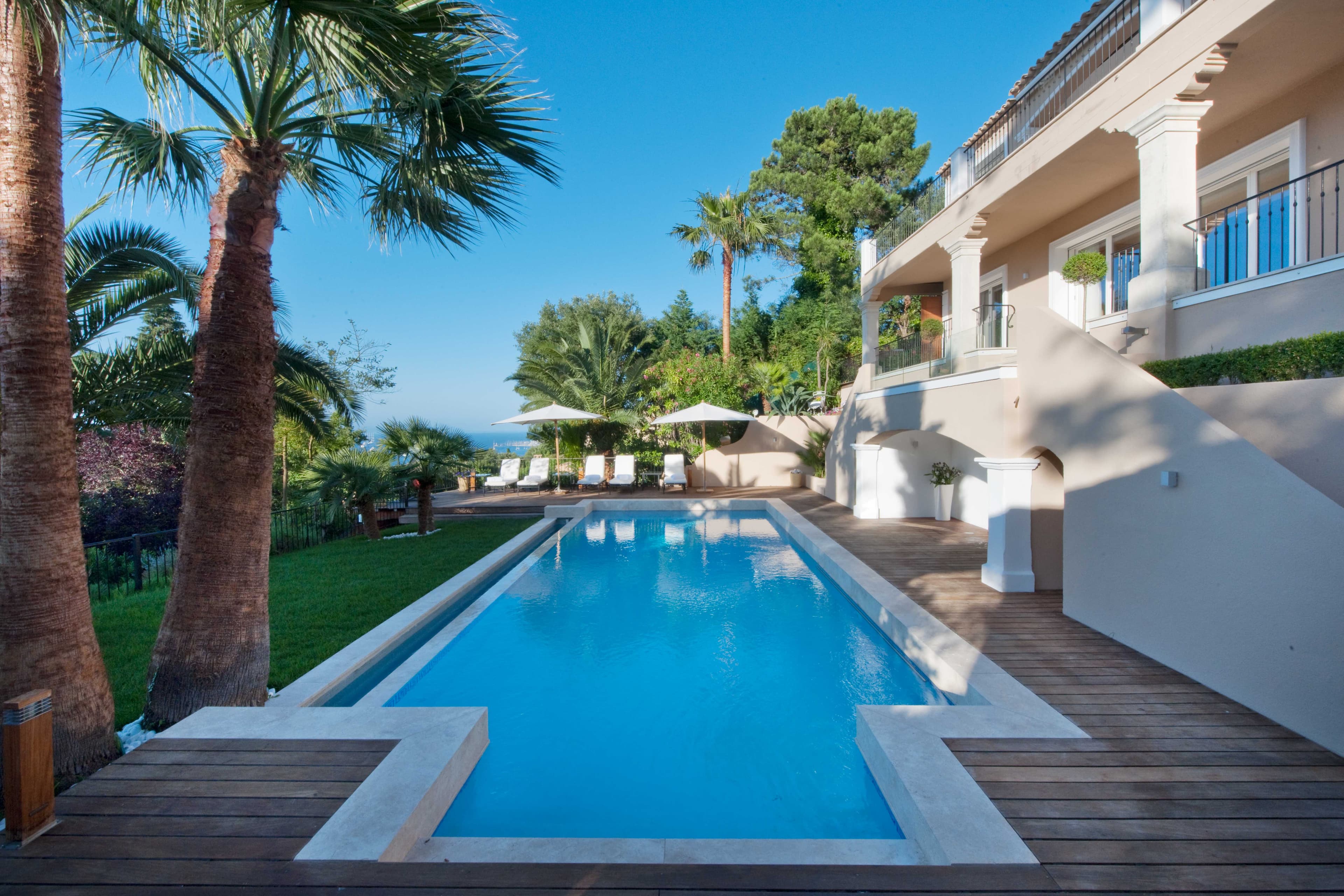 Piscine chauffée entourée d’un jardin paysager dans une villa avec vue panoramique sur la mer à Gassin.