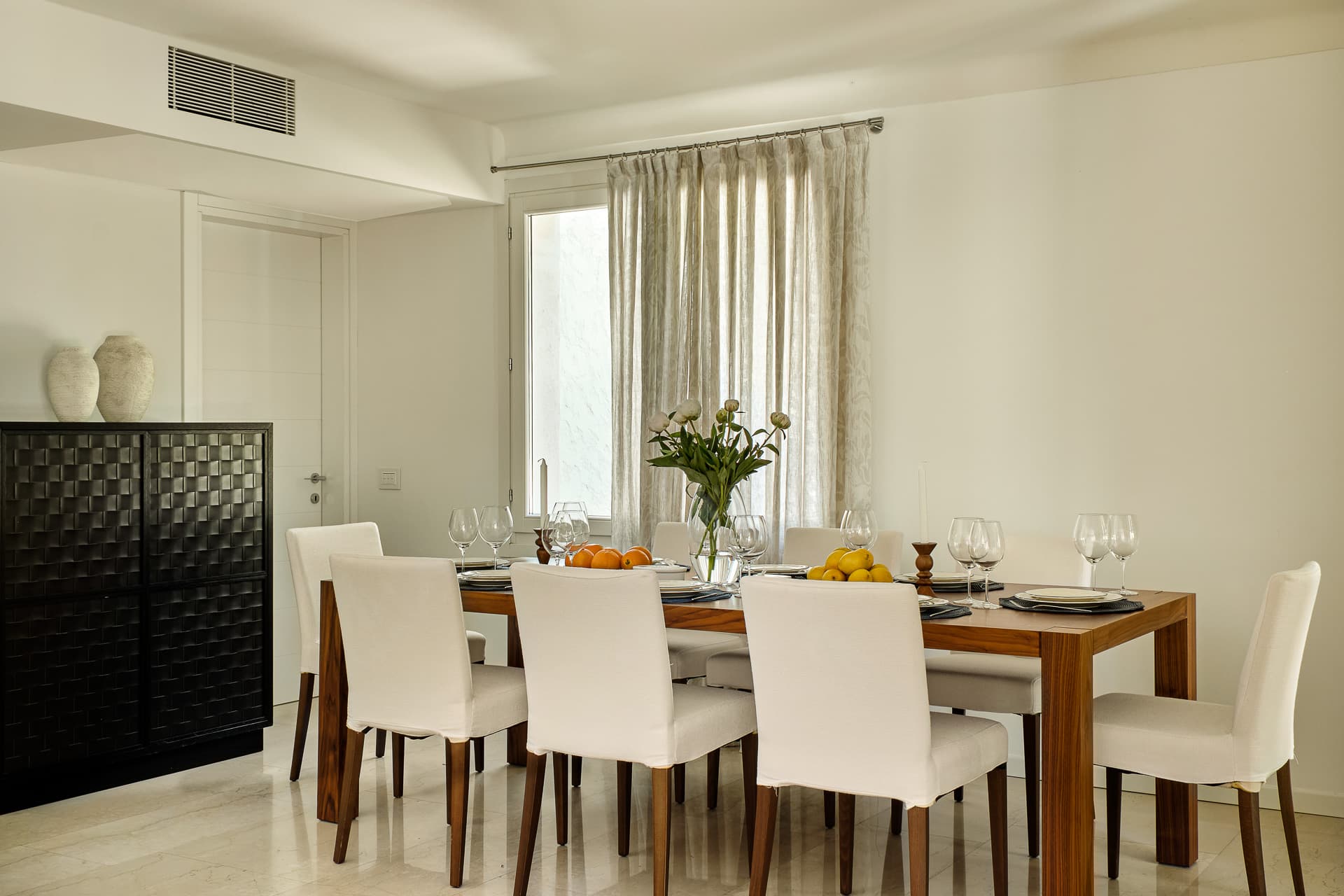Salle à manger raffinée ouverte sur les espaces extérieurs d’une propriété de prestige à Saint-Tropez.