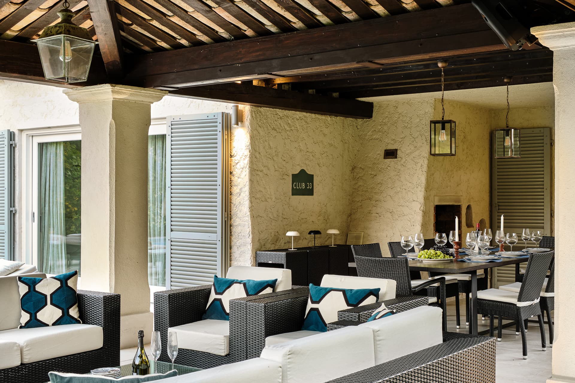 Élégante terrasse couverte avec espace repas extérieur donnant sur le jardin et la piscine.