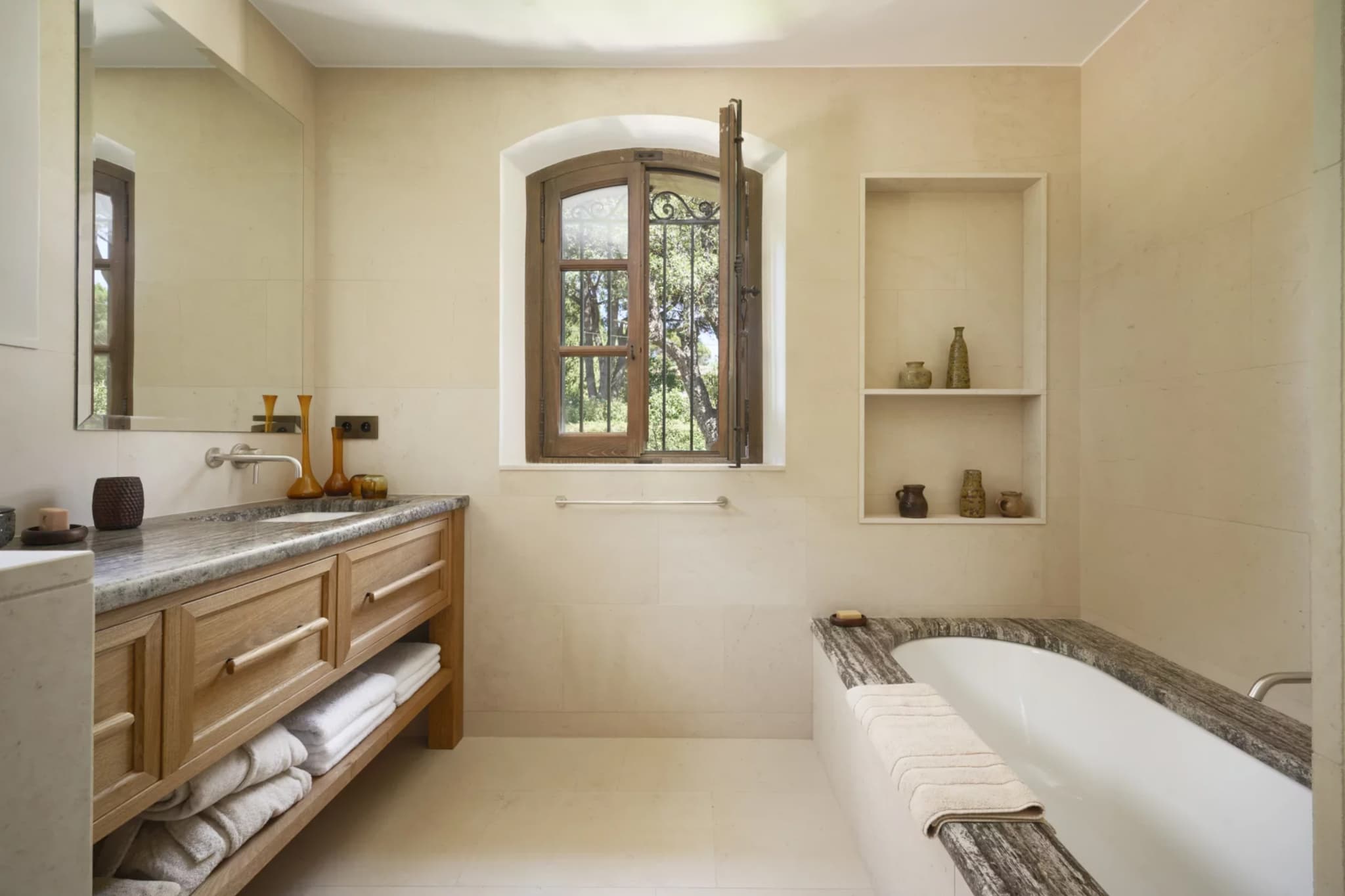 Salle de bain élégante en pierre naturelle avec douche à l’italienne, dans une villa provençale luxueuse à vendre à Saint-Tropez.