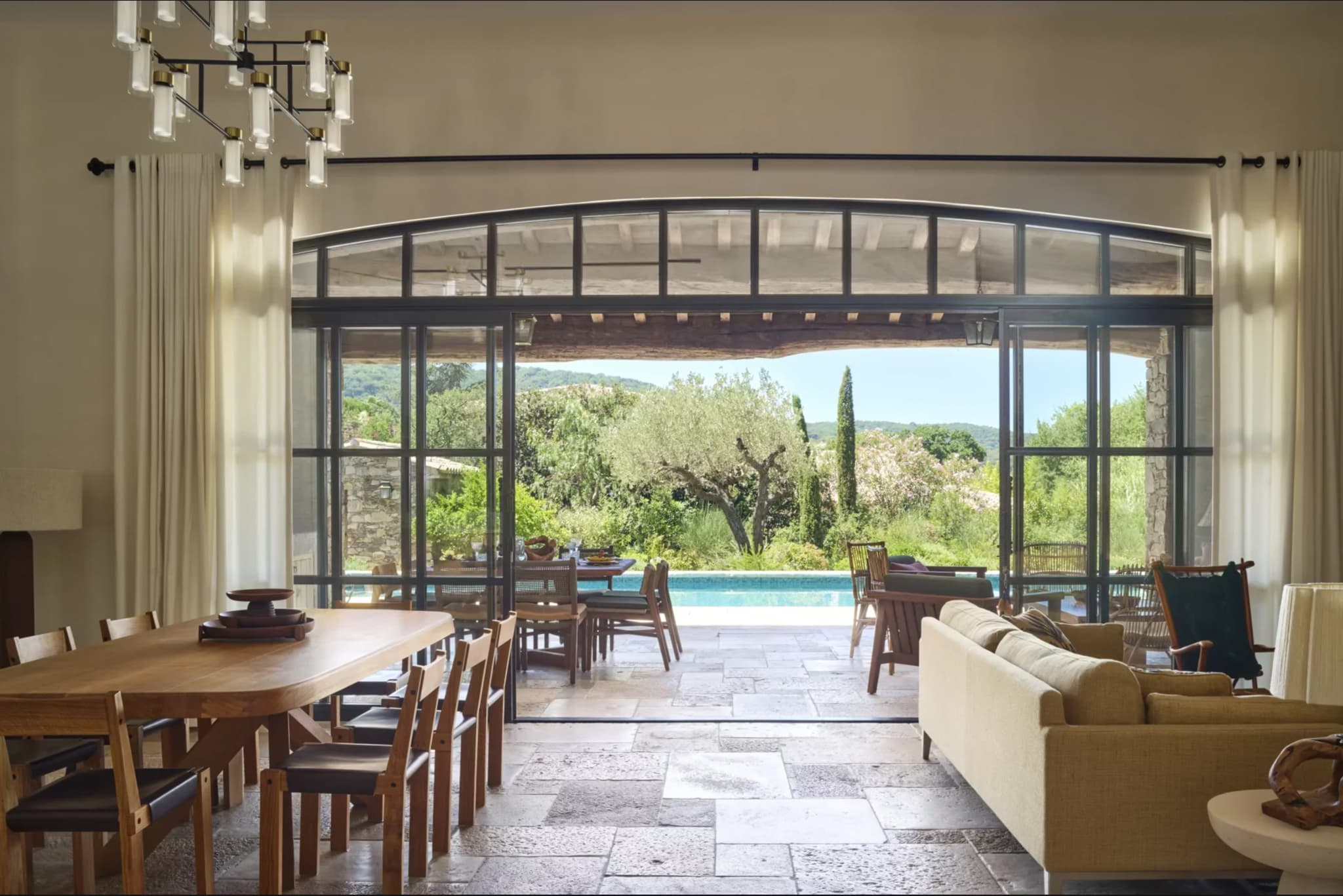 Grande terrasse couverte en pierre donnant sur le jardin paysager, dans une villa provençale d’exception à vendre à Saint-Tropez.