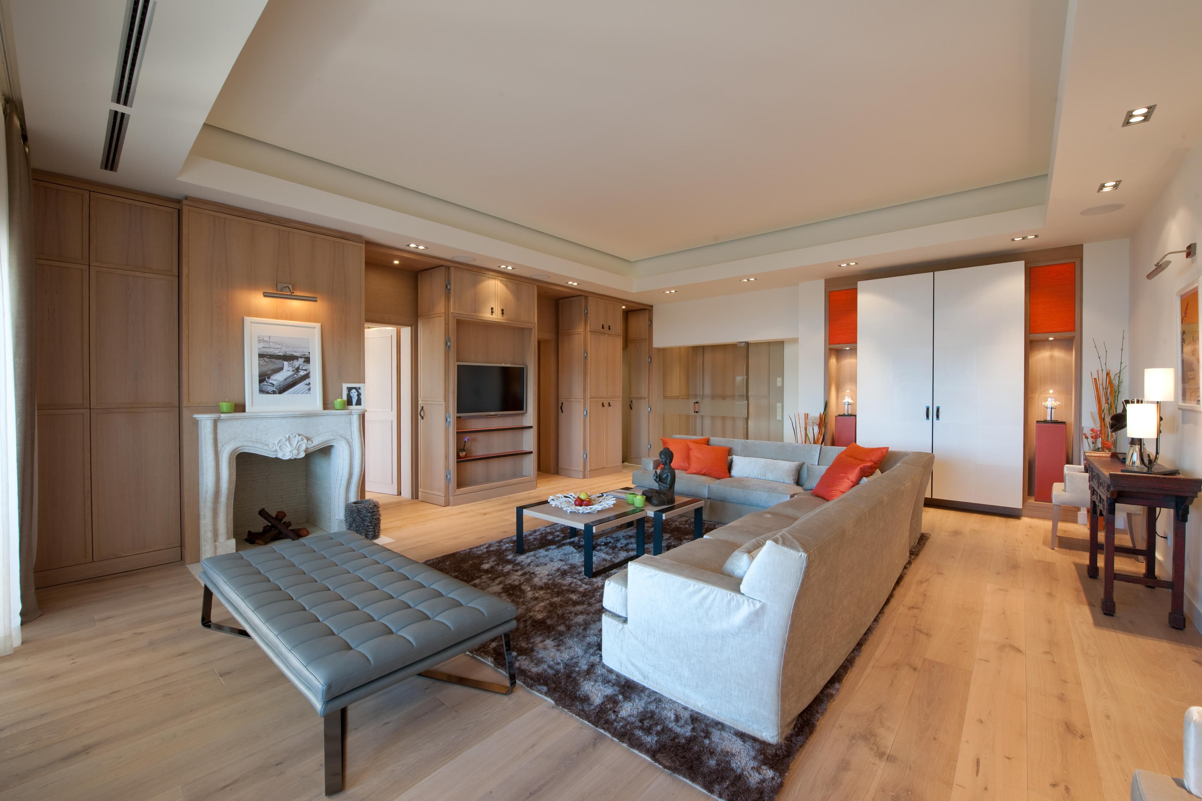 Salon lumineux avec cheminée et larges ouvertures sur les terrasses d’une propriété exclusive à Gassin près de Saint-Tropez.