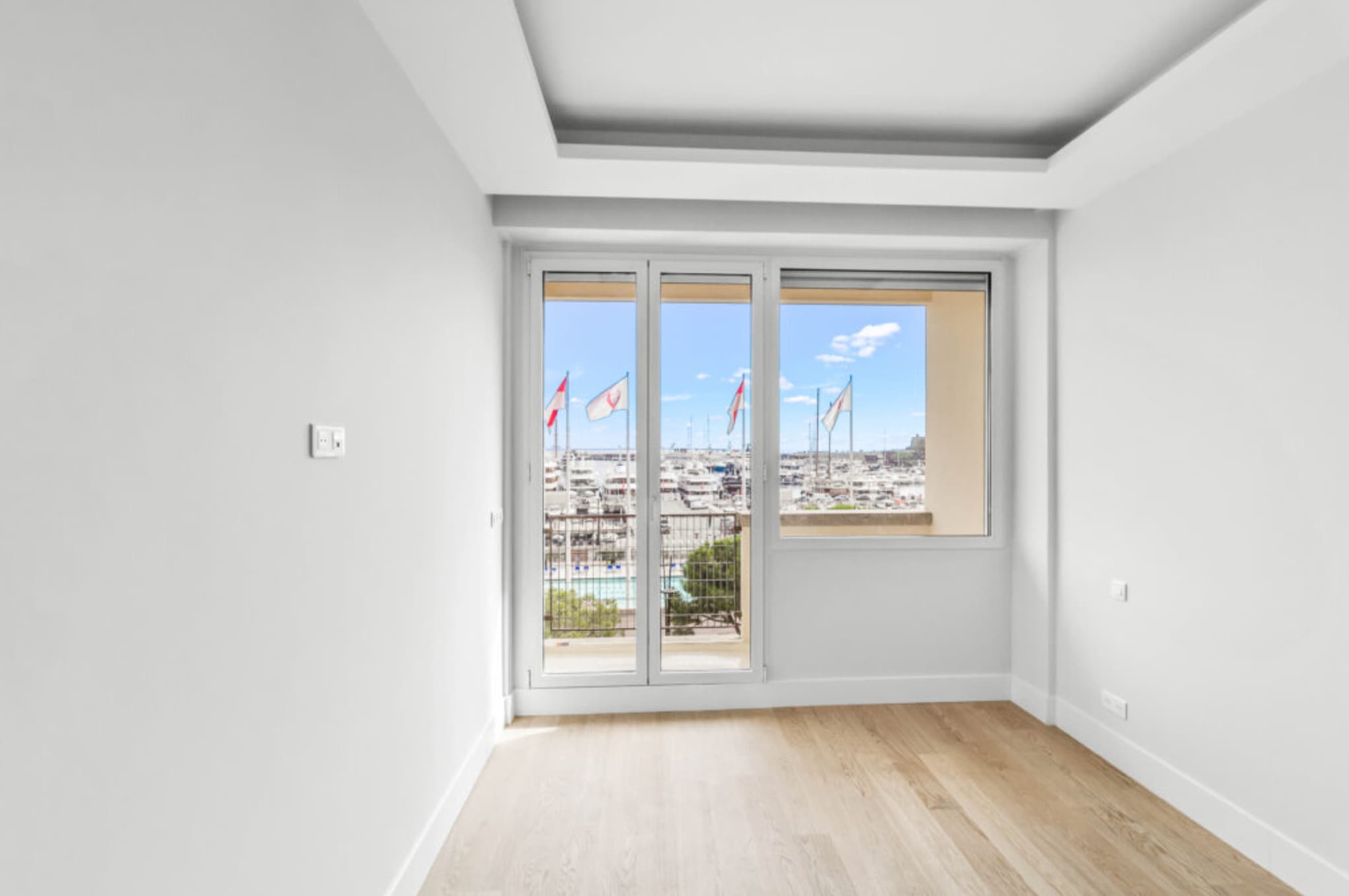 Séjour spacieux et lumineux dans un appartement à vendre à Monaco, offrant confort et élégance avec vue sur le port.