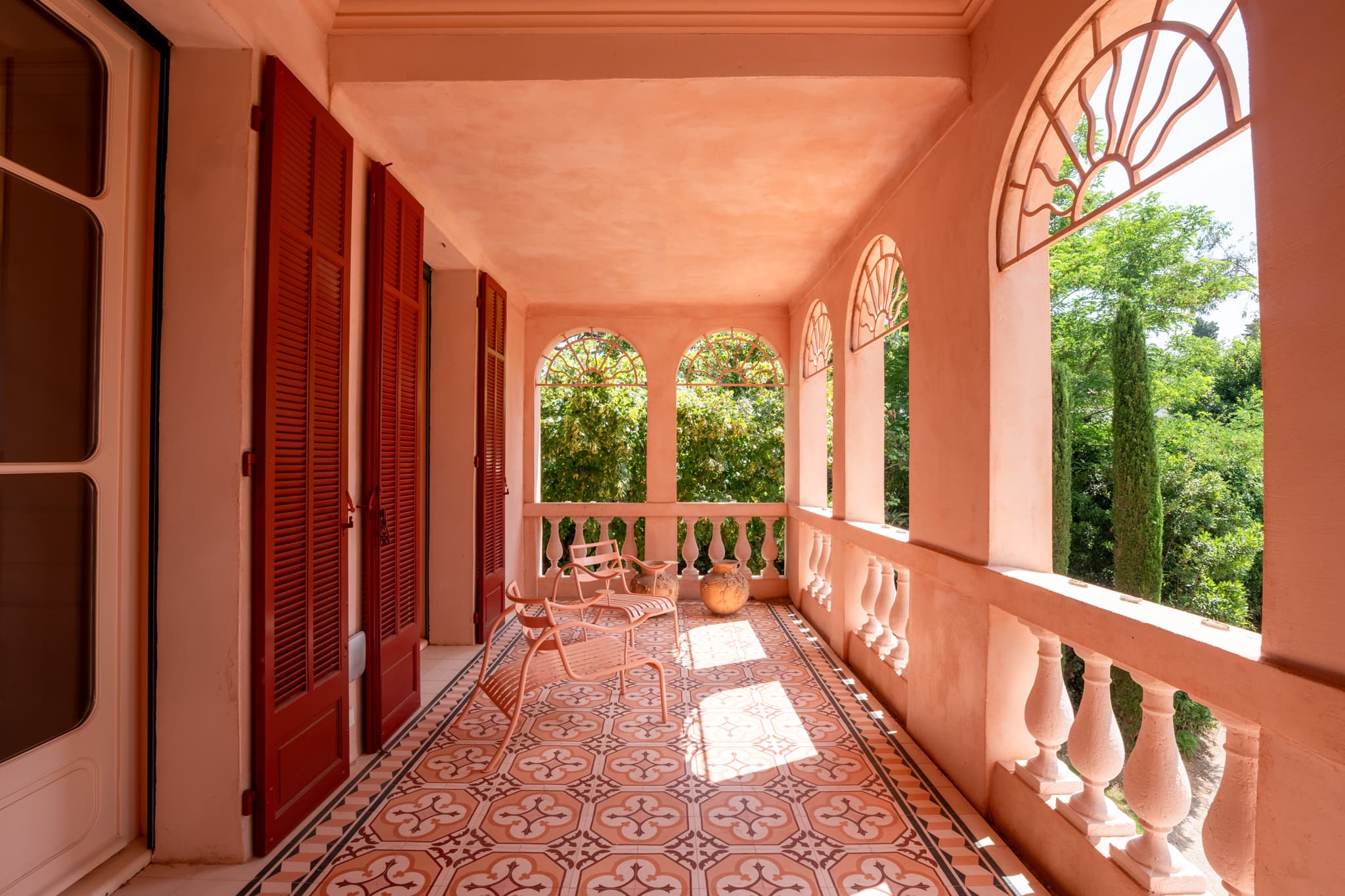 Terrasse couverte ouverte sur le jardin paysager, parfaite pour les réceptions et les moments de détente à Saint-Tropez.