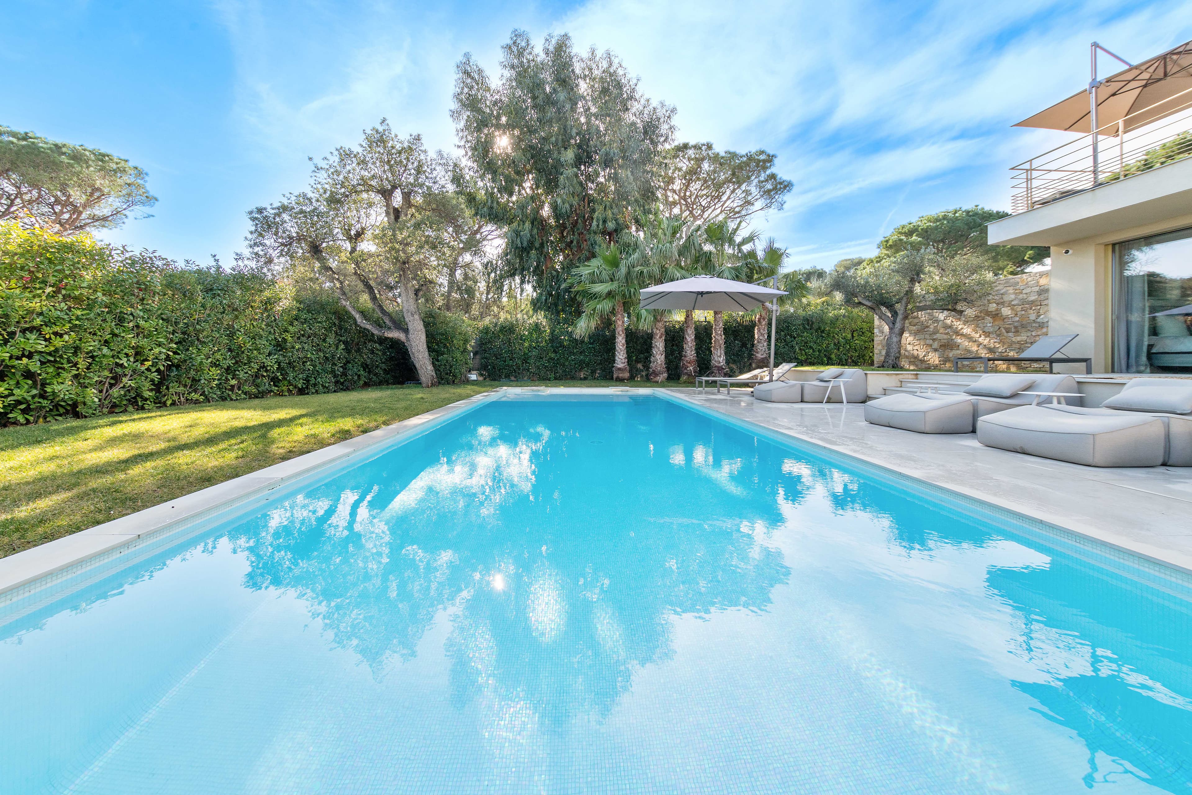 Grande piscine chauffée avec vue mer dans villa de luxe à vendre à Saint-Tropez. Espace détente et soleil toute la journée.