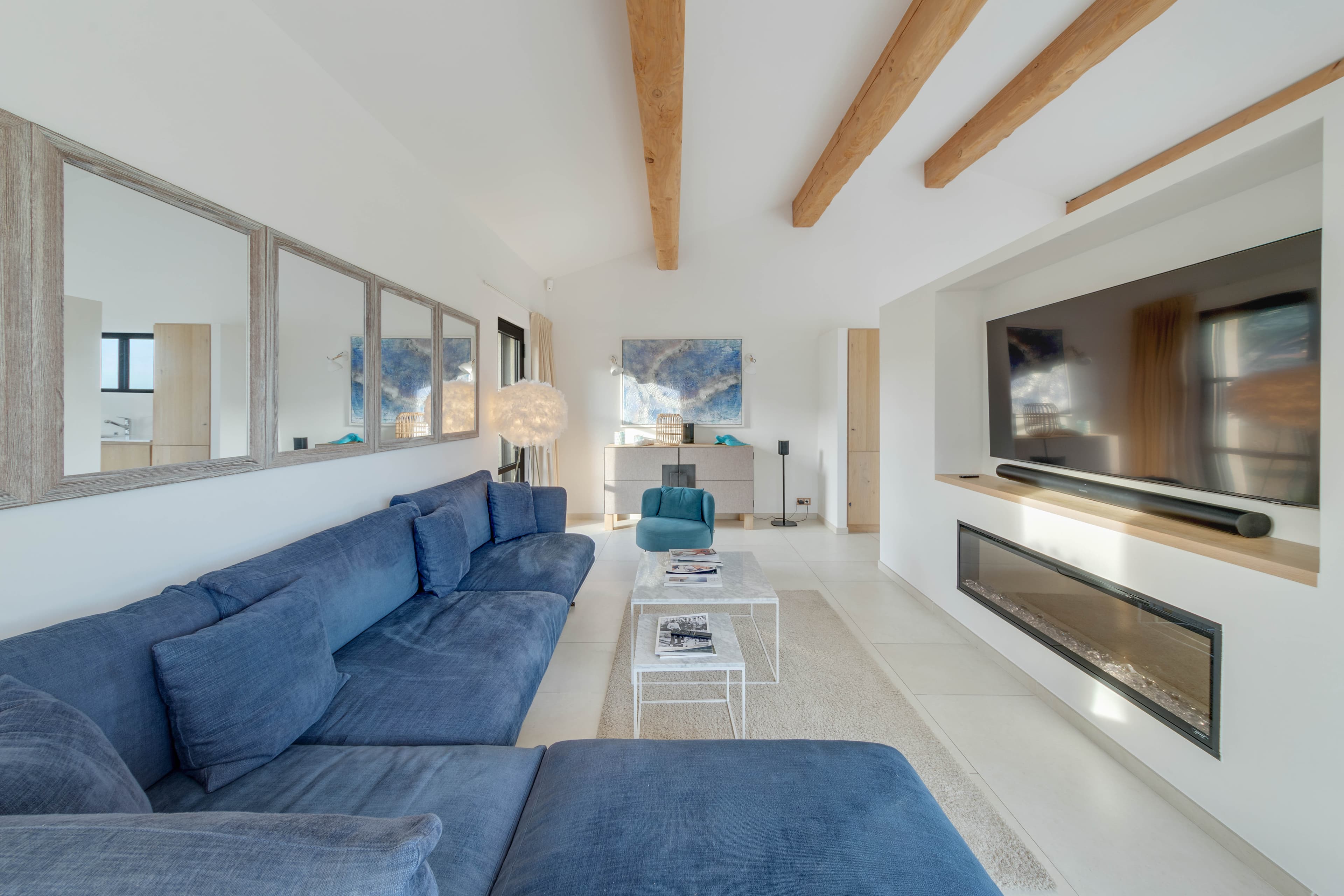 Salon spacieux au style marin dans une villa à vendre (2021). Tons blancs, bois naturel et vues sur la Méditerranée.