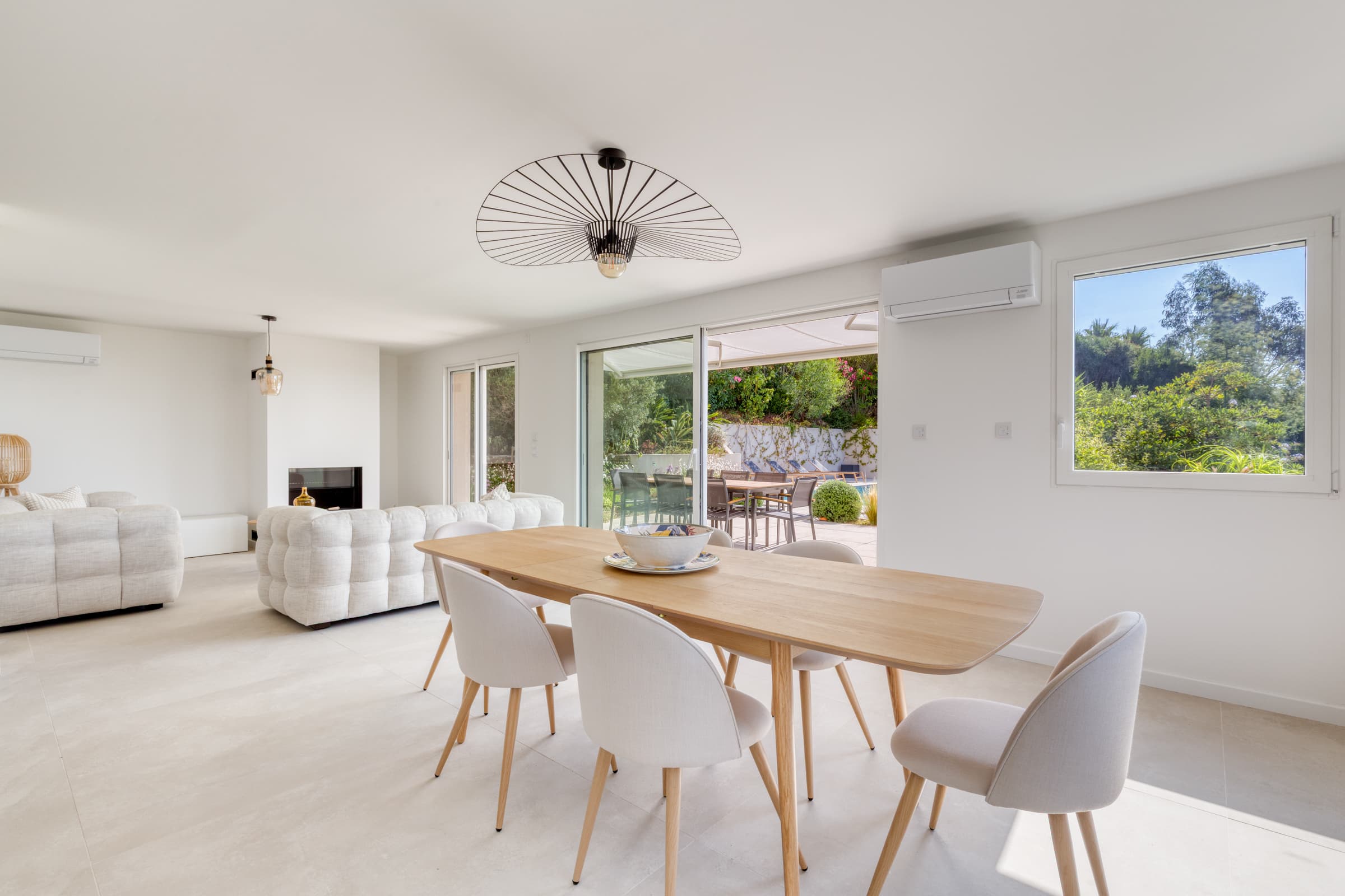 Villa à vendre à Cavalaire-sur-Mer : Salle à manger spacieuse avec cheminée et accès terrasse vue mer.