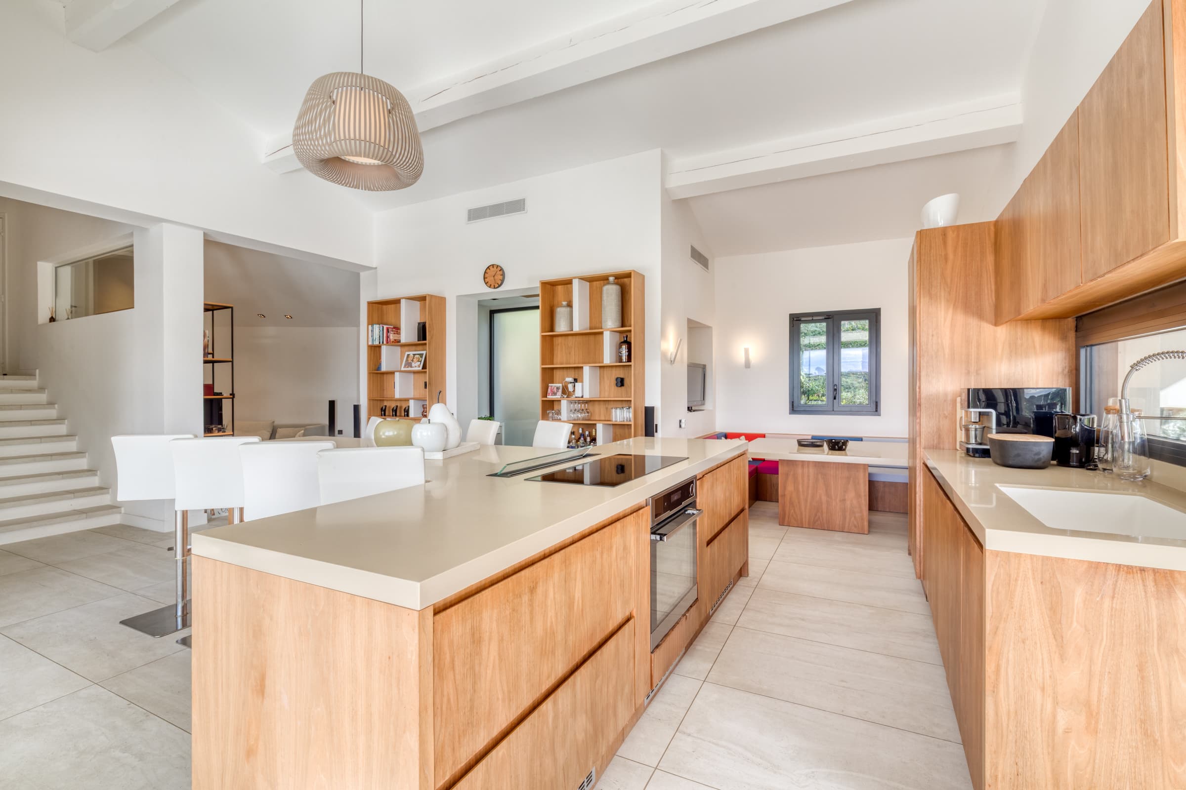 Cuisine contemporaine entièrement équipée de la villa à vendre, ouverte sur les terrasses et la Méditerranée.