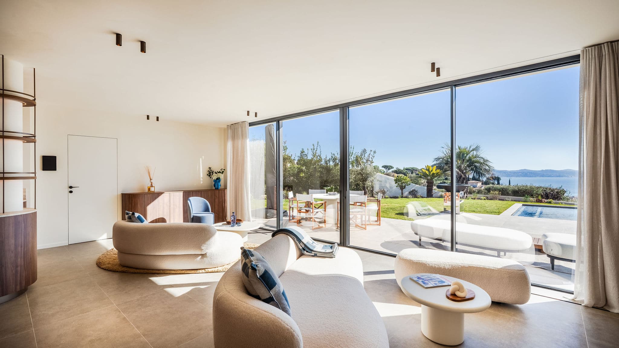 Séjour spacieux et lumineux avec grandes baies vitrées, ouvert sur les terrasses et offrant une vue dégagée sur la mer.